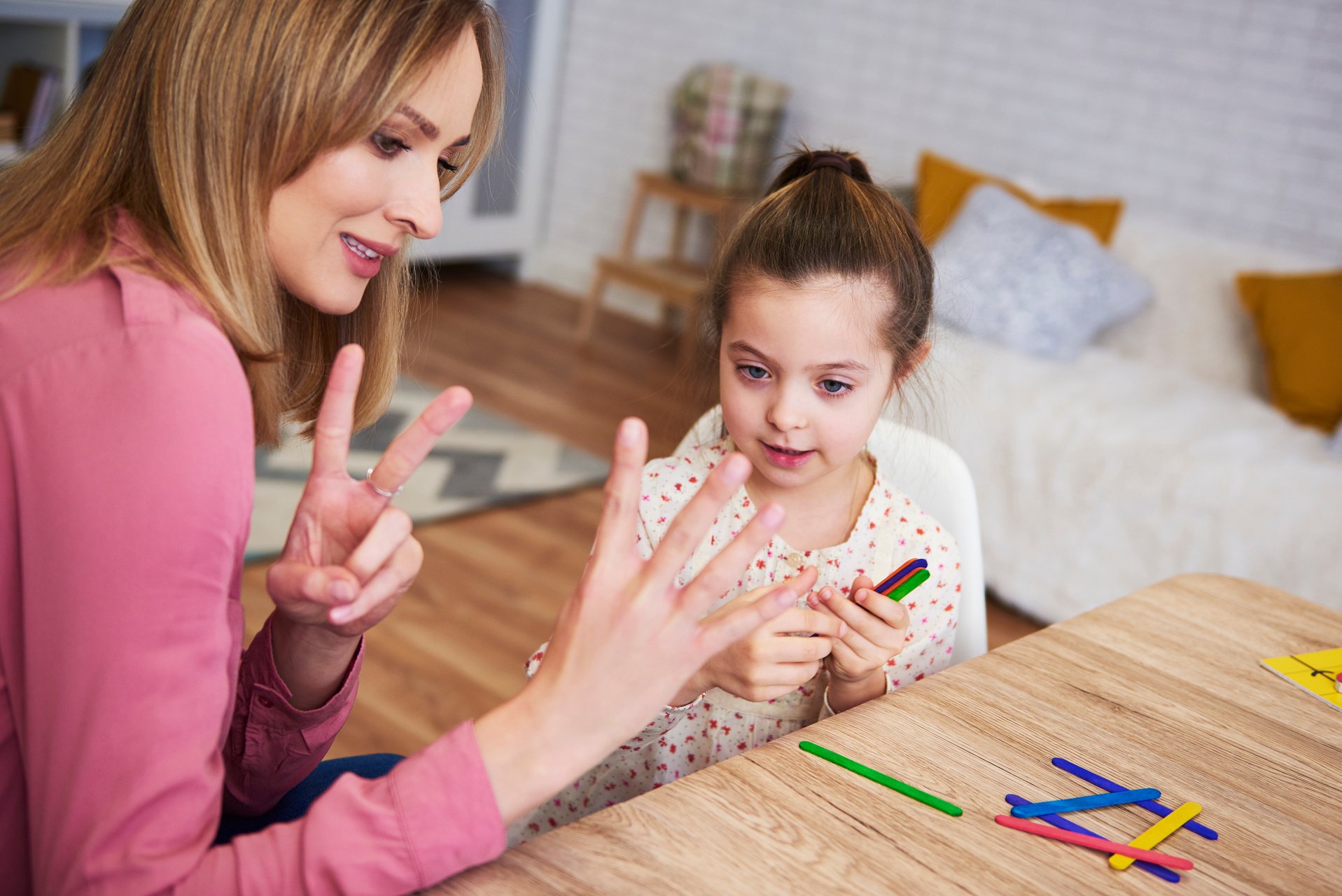 Young mum teaching child to count at home