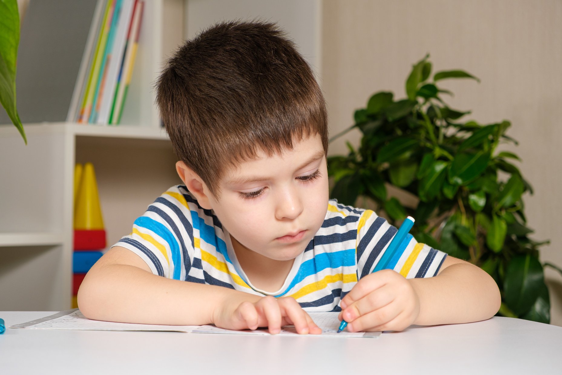 Preschool child learns to write, writes copybook.